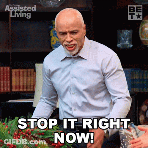 A Man Is Standing In Front Of A Wreath And Says Stop It Right Now GIF