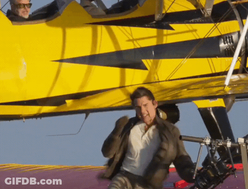 A Man Is Standing In Front Of A Yellow Plane GIF