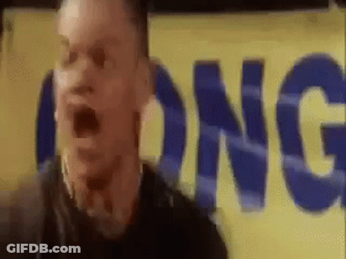 A Man Is Standing In Front Of A Yellow Sign That Says Long GIF