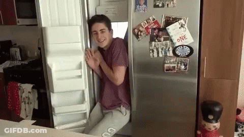 A Man Is Standing In Front Of An Open Refrigerator With A Card That Says One On It GIF