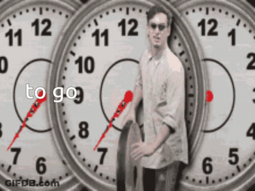 A Man Is Standing In Front Of Three Clocks With The Words To Go Written On The Bottom GIF