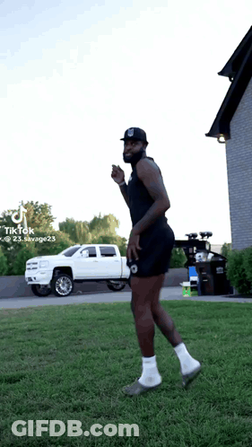 A Man Is Standing In The Grass With A White Truck In The Background And A Tiktok Watermark On The Bottom Right GIF