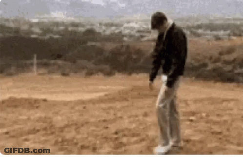 A Man Is Standing In The Middle Of A Dirt Field GIF