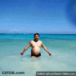 A Man Is Standing In The Ocean With Twitter-Gifs.professor-Falken.com Written On The Bottom GIF