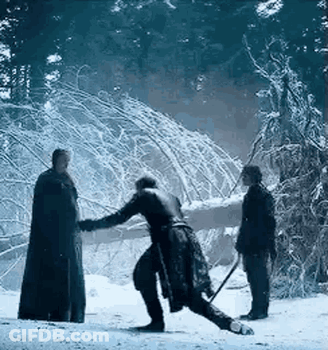 A Man Is Standing In The Snow Holding A Sword While Another Man Looks On . GIF