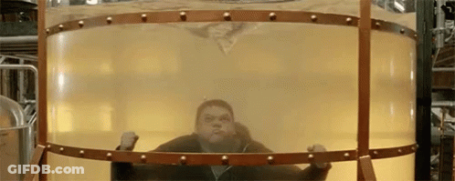 A Man Is Standing Inside Of A Large Cylindrical Container Filled With Liquid . GIF