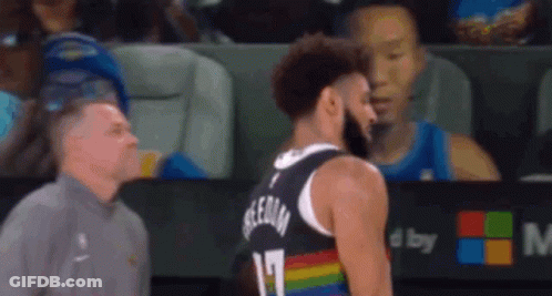 A Man Is Standing Next To A Basketball Player Who Is Wearing A Rainbow Colored Jersey . GIF