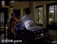A Man Is Standing Next To A Car In A Parking Garage GIF
