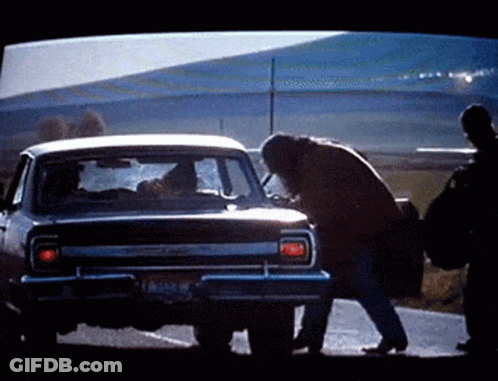 A Man Is Standing Next To A Car With A License Plate That Says ' Lc ' On It GIF