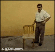 A Man Is Standing Next To A Chair With A 4Gifs.com Watermark On The Bottom Right GIF