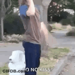 A Man Is Standing Next To A Fire Hydrant With A Dog And A Sign That Says `` So No Kiss ? '' . GIF