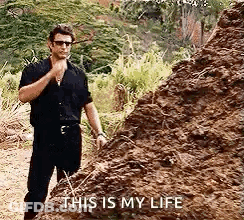 A Man Is Standing Next To A Pile Of Dirt And Talking To Himself . GIF