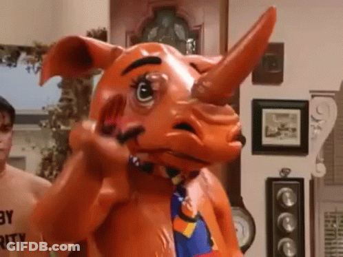 A Man Is Standing Next To A Rhino Mascot Costume In A Living Room . GIF