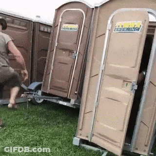 A Man Is Standing Next To A Trailer With Portable Toilets Attached To It And One Of Them Is Open GIF