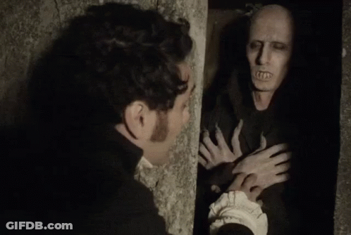A Man Is Standing Next To A Wall Looking At A Monster . GIF