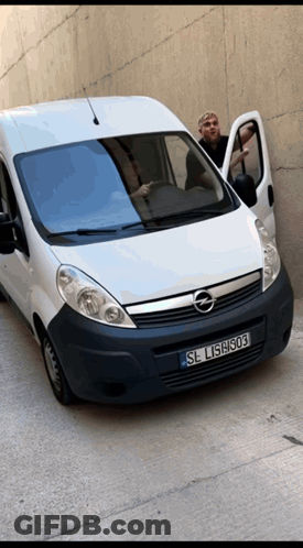 A Man Is Standing Next To A White Van With License Plate Sl L15h303 GIF