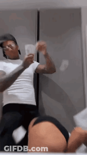 A Man Is Standing Next To A Woman In A Bathroom Holding A Bunch Of Money In Front Of A Mirror . GIF