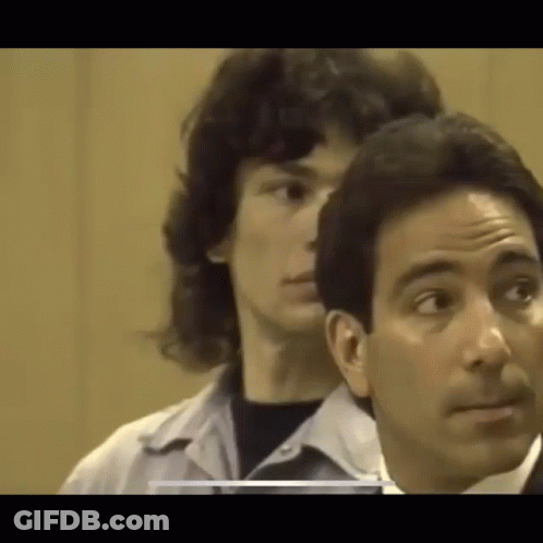 A Man Is Standing Next To A Woman In A Courtroom . GIF