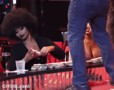 A Man Is Standing Next To A Woman Sitting At A Table . GIF