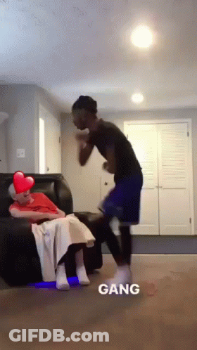 A Man Is Standing Next To A Woman Sitting On A Couch And The Word Gang Is On The Bottom GIF