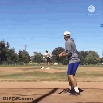 A Man Is Standing On A Baseball Field Holding A Baseball . GIF