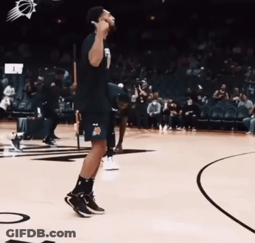 A Man Is Standing On A Basketball Court And Giving A Thumbs Up . GIF