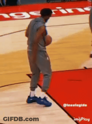 A Man Is Standing On A Basketball Court Holding A Basketball In His Hand . GIF