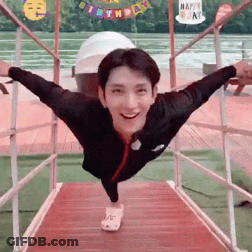 A Man Is Standing On A Bridge With His Arms Outstretched . GIF