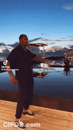 A Man Is Standing On A Dock With A Tiktok Watermark On The Bottom GIF