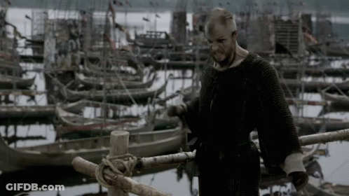 A Man Is Standing On A Dock With Boats In The Background GIF