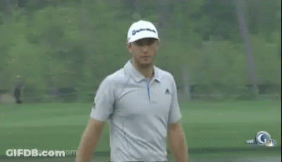 A Man Is Standing On A Golf Course Wearing A Hat And A Polo Shirt . GIF