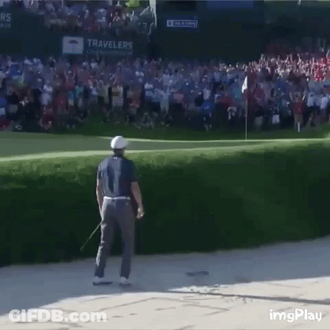 A Man Is Standing On A Golf Course With A Crowd Behind Him And A Sign That Says Travelers On It GIF