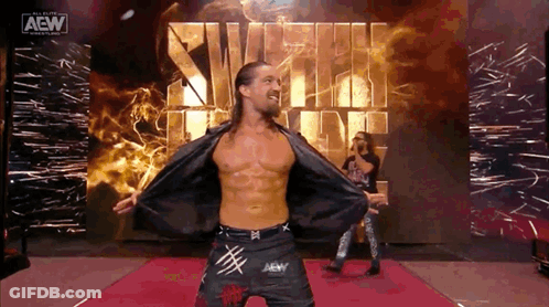 A Man Is Standing On A Red Carpet With His Arms Outstretched . GIF