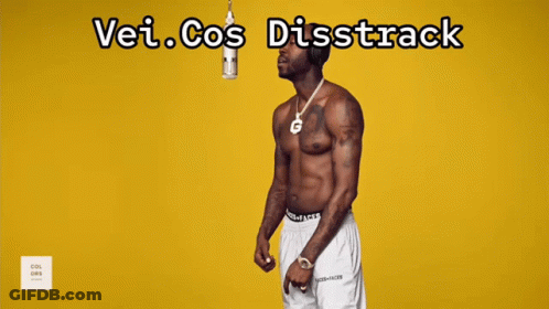 A Man Is Standing On A Red Mat In Front Of A Yellow Wall With The Words " Vei Cos Distrack " Written Above Him GIF