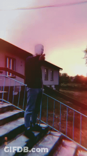 A Man Is Standing On A Set Of Stairs Taking A Picture With His Phone GIF