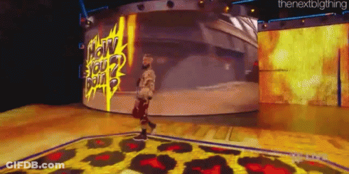 A Man Is Standing On A Stage In Front Of A Large Screen That Says " How You Doin " . GIF