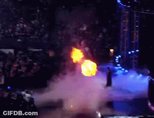 A Man Is Standing On A Stage With A Fireball Coming Out Of His Chest GIF