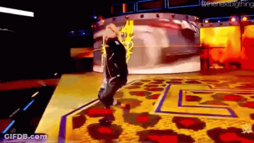A Man Is Standing On A Stage With A Leopard Print Rug And A Yellow Background . GIF
