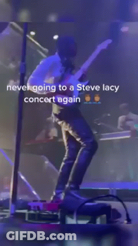 A Man Is Standing On A Stage With A Microphone And A Caption That Says Never Going To A Steve Lacy Concert Again GIF