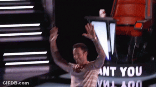 A Man Is Standing On A Stage With His Arms In The Air In Front Of A Sign That Says Ant You GIF