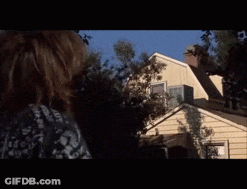 A Man Is Standing On The Roof Of A House In A Scene From A Movie GIF