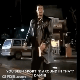 A Man Is Standing On The Side Of The Road Holding A Gun And Talking . GIF