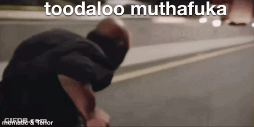 A Man Is Standing On The Side Of The Road With The Words Toodaloo Muthafuka Above Him . GIF