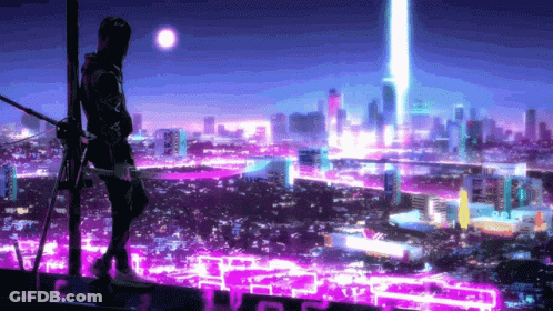 A Man Is Standing On Top Of A Building Looking At A City At Night GIF