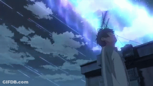A Man Is Standing On Top Of A Building Looking Up At A Starry Night Sky . GIF
