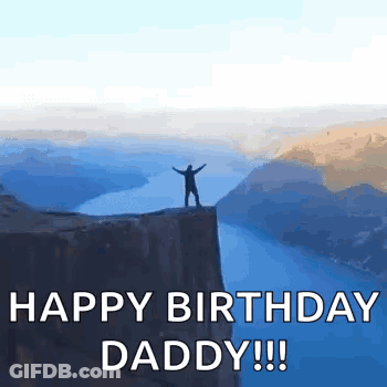 A Man Is Standing On Top Of A Cliff Overlooking A Body Of Water . GIF