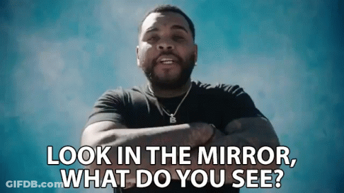 A Man Is Standing With His Arms Crossed And Says " Look In The Mirror What Do You See " GIF