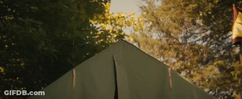 A Man Is Sticking His Head Out Of A Tent GIF