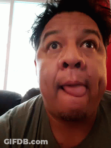 A Man Is Sticking His Tongue Out And Making A Funny Face GIF