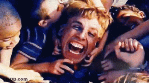 A Man Is Surrounded By Children And Laughing . GIF